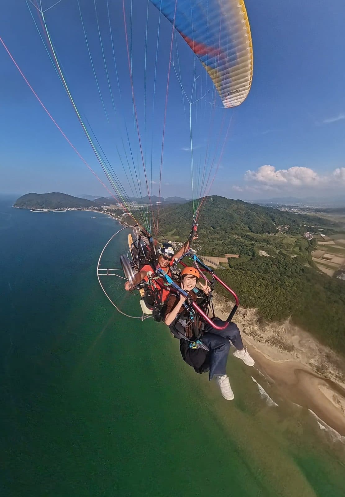 Flying tandem with the instructor, with Itoshima's sea below